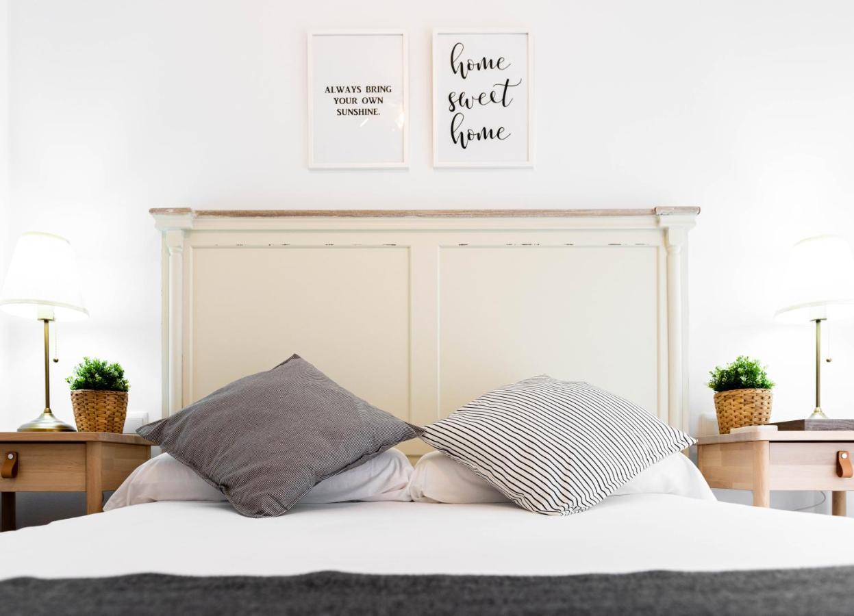 Apartamentos Toboso Plaza เนร์คา ภายนอก รูปภาพ A bedroom with a bed and two bedside tables